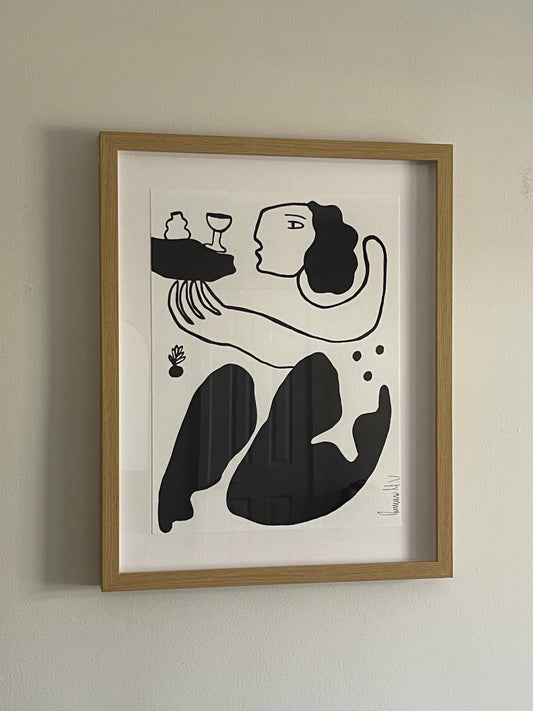 Framed black and white abstract artwork on a beige wall